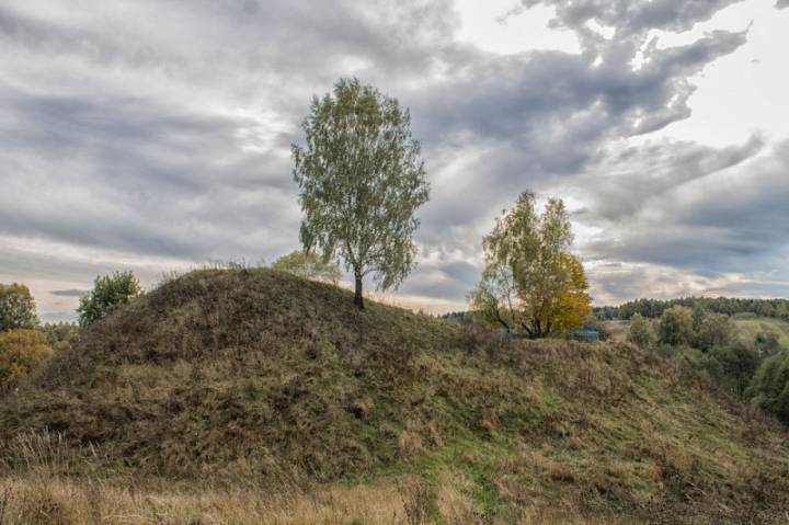  Radoml, agrotown (Radamlski rural council). История создания<br><br>В древние времена Радомля была одним из центров поселения племени радимичей. Именно от них произошло и название города. Еще тогда в этом месте существовало укрепленное городище. Позже на его месте возник замок. Произошло это приблизительно в XIII веке. <br>Замок был построен на левом берегу реки Радучь, на месте древнего городища. Площадь городища – 53 на 40 метров. С севера оно было защищено валом высотой около 5 метров и шириной 8 метров у основания. Само городище возвышается над окрестными землями на 15-18 метров.<br>Стены замка были деревянные и выполнены в виде частокола, а также городен. У него было 4 башни, в том числе одна брамная. Кроме этого, был еще тайный выход к реке через скрытую дверь.<br>На территории замка находился колодец, который снабжал обороняющихся водой.<br>Замок был очень массивным и имел большие погреба. По некоторым данным, на его содержание работала вся волость, и половина выращенного пшена отдавалось гарнизону замка, на случай его осады.<br>При обороне замка использовалась артиллерия.<br><br>Радомль находился недалеко от земель Русского царства. Поэтому практически ни одна крупная война не обошла его стороной.<br><br>Большие разрушения замок пережил во время осады 1535 года, а во время Ливонской войны он трижды горел.<br>Во время «кровавого потопа» в 1654-1657 годах в замке формировался казачий полк Константина Поклонского.<br><br>Интересно, что о боевых действиях вокруг замка во время этой войны никаких сведений нет. Но после этого он перестал упоминаться в исторических летописях.<br><br>Замок был разрушен во время военных действий 1654-1660 годов. Но достоверно неизвестно.<br><br>Сейчас сохранилось древнее городище радимичей, на территории которого размещался замок, и сегодня возвышается над всеми окрестностями. Хотя со времен существования замка оно явно уменьшилось в размерах. Сегодня на нем растут деревья.<br><br>Есть легенда, что в самом начале на месте замкового колодца стояла церковь. Но позже она ушла под землю и на этом месте образовался колодец со святой водой.